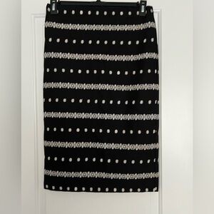 Black pencil skirt with floral embroidery.